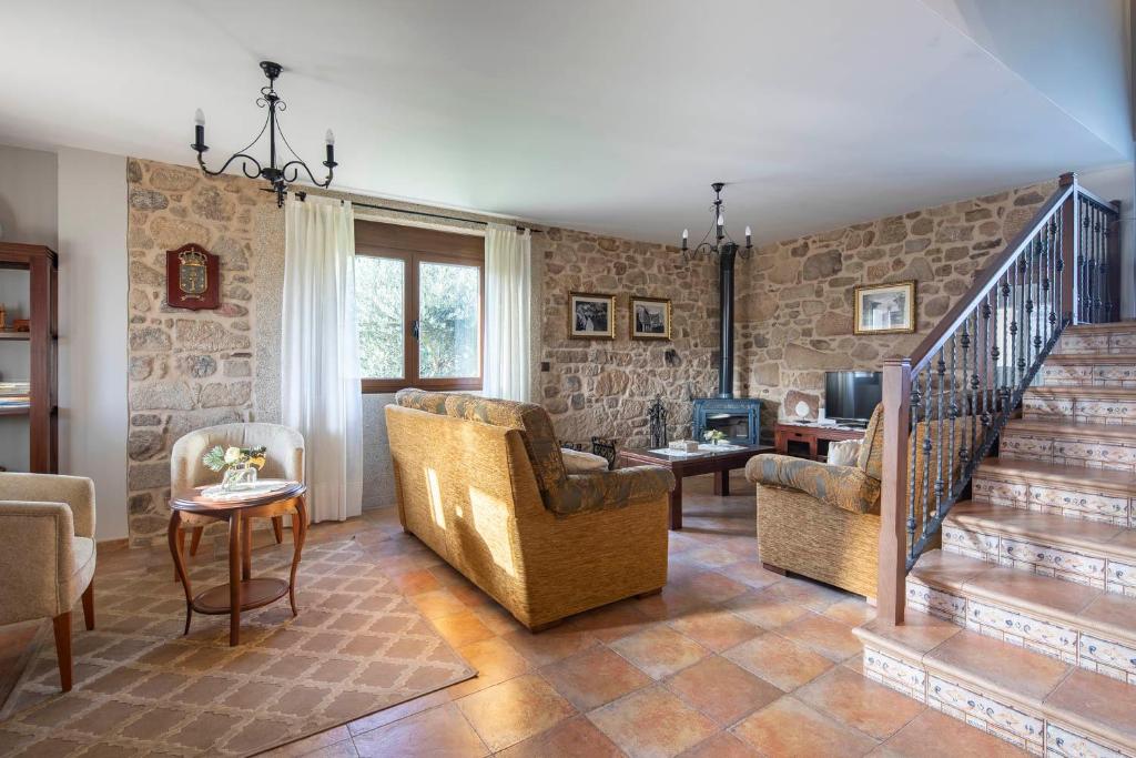 sala de estar con escalera y pared de piedra en Casas Lar de Arousa I y II, en Catoira