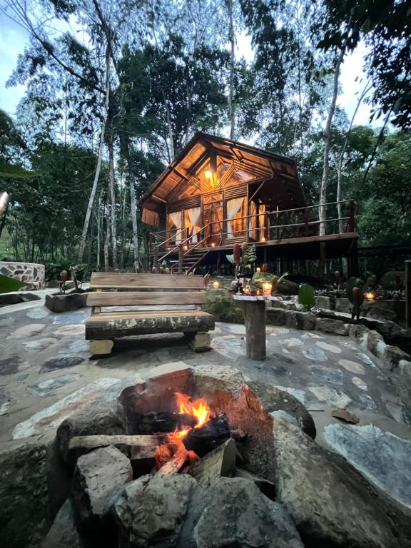 uma cabana de madeira com uma fogueira à sua frente em Sikeo Eco Glamping em Icononzo
