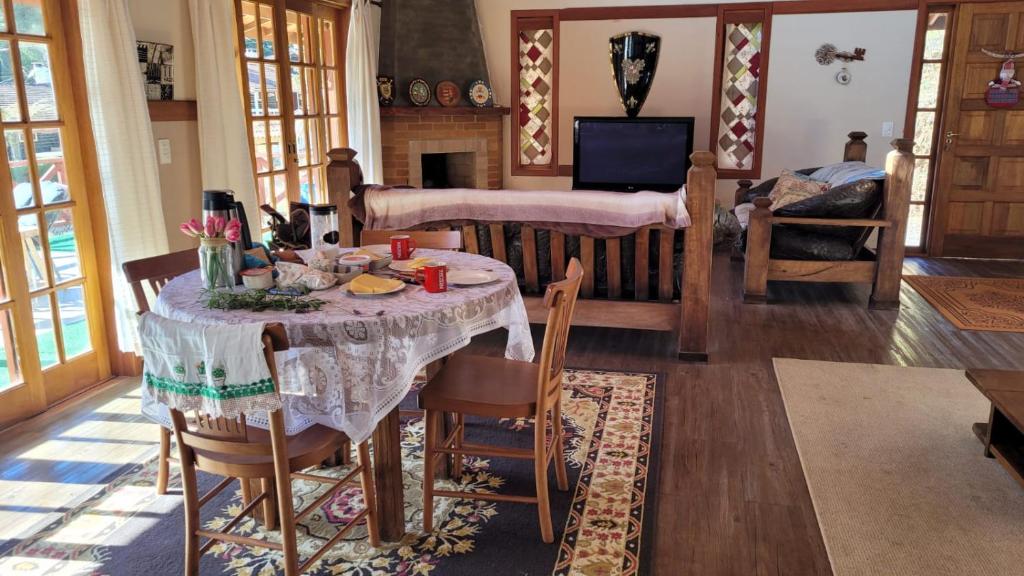 - un salon avec une table et une cheminée dans l'établissement MonteVerdeMG, Fibra Óptica, fácil acesso, térrea ., à Monte Verde