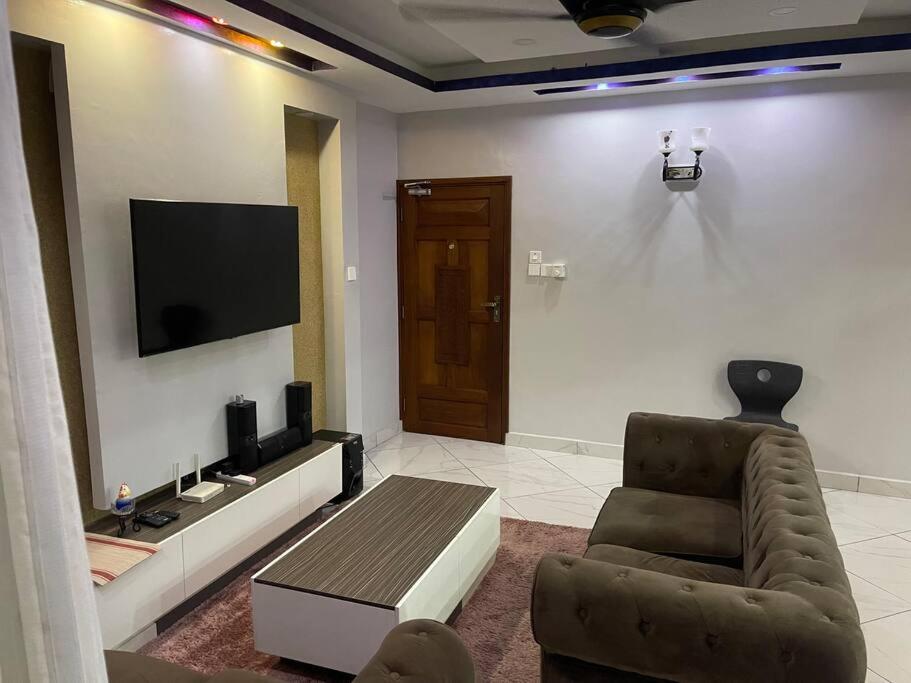 een woonkamer met een bank, een stoel en een televisie bij Classy 3 bedroom apartment in Mombasa. in Mombasa