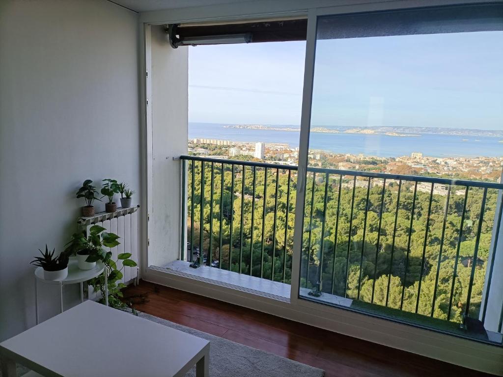 a room with a balcony with a view of the ocean at VUE MER et montagne dans parc du roy d'espagne, Up to 7 people in Marseille