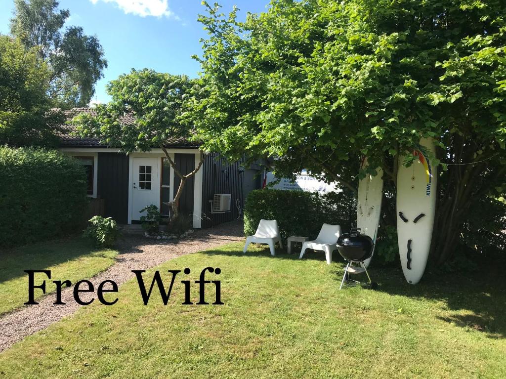 a backyard with a tree with a grill and a tree at 3:e Sandbank in Beddinge Strand