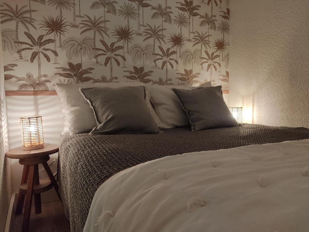 sypialnia z łóżkiem i ścianą z palmami w obiekcie Appartement cosy Saint Lary village w mieście Saint-Lary-Soulan