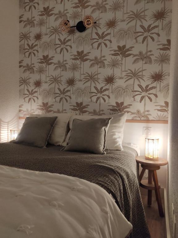 sypialnia z łóżkiem i tapetą w kwiaty w obiekcie Appartement cosy Saint Lary village w mieście Saint-Lary-Soulan