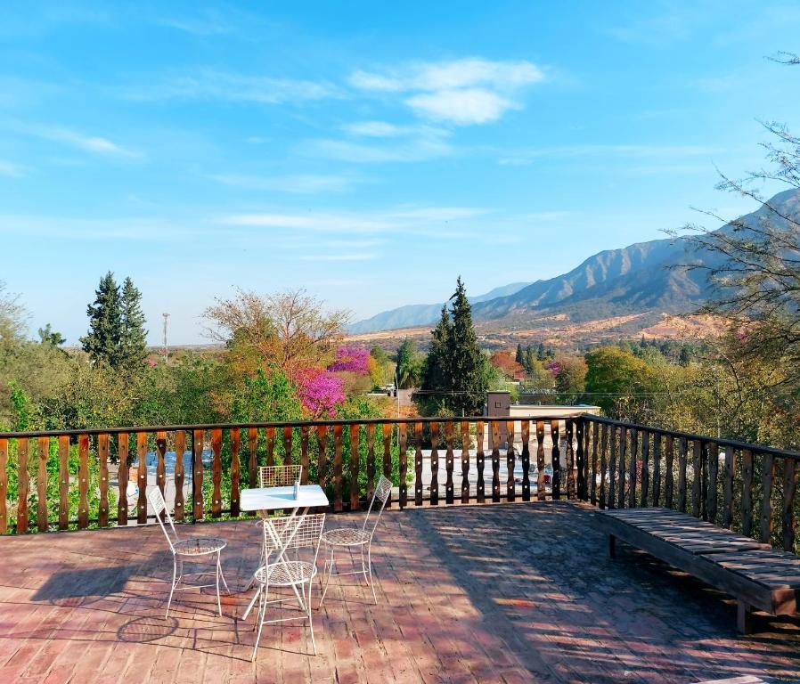 una terraza con sillas, un banco y montañas en AV Rent a Car y Alquiler temporario Casa quinta en La Rioja