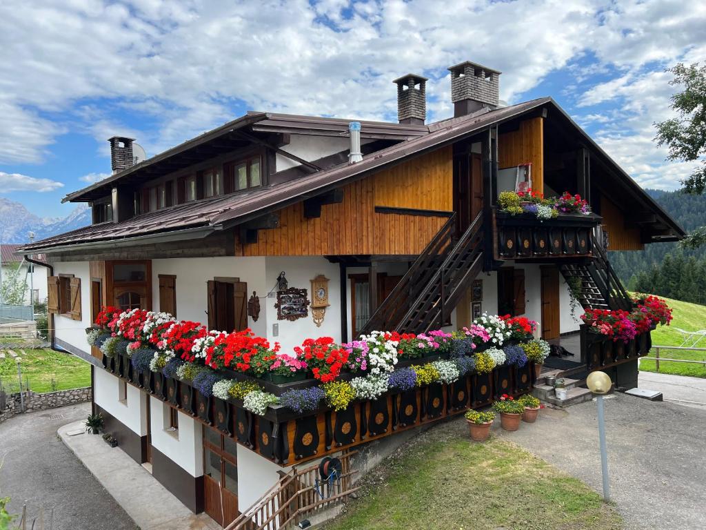 une maison avec des fleurs sur son côté dans l'établissement La Maisonette 1878, à Dosoledo