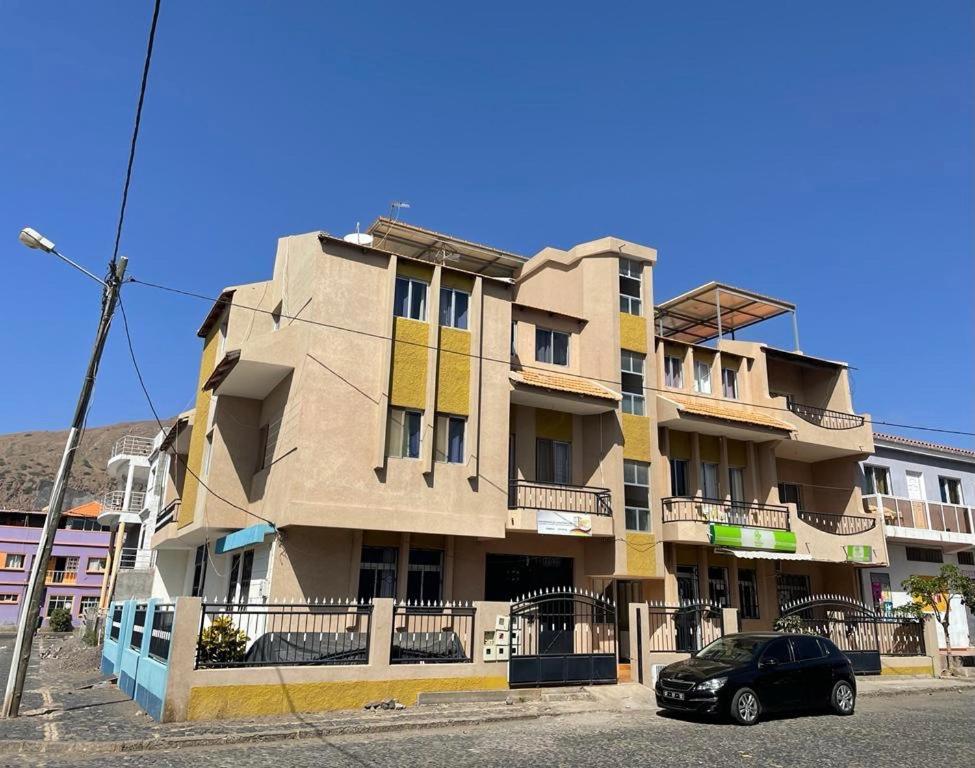 a building with a car parked in front of it at Apartamento T2-Dunas Centro in Tarrafal