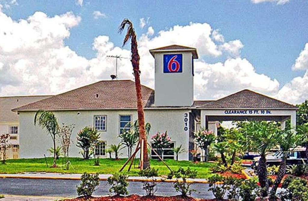 un hotel con una palmera frente a un edificio en Motel 6-Pasadena, TX, en Pasadena