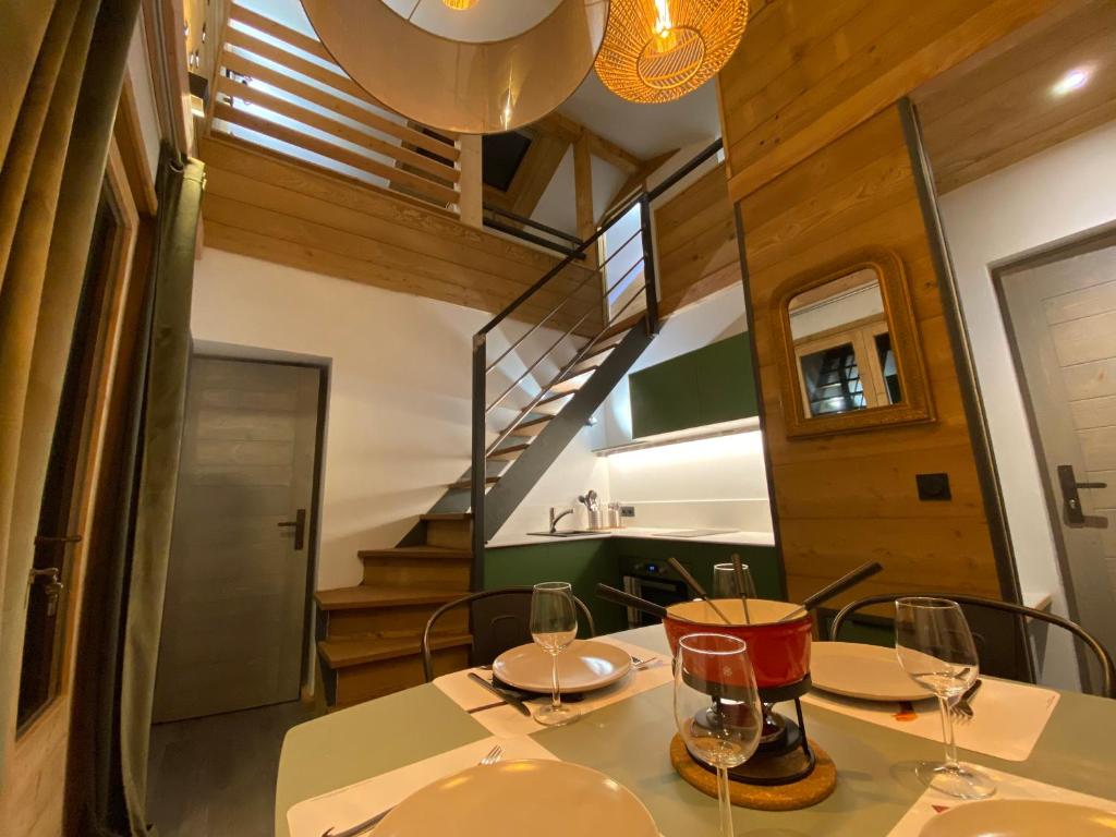 een eetkamer met een tafel met wijnglazen erop bij Genepi loft duplex 4 personnes in Arâches-la-Frasse