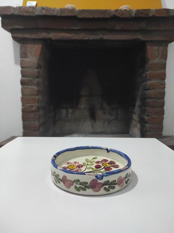 a bowl of food sitting on a table in front of a fireplace at Traditional Stone House in Mantamádos
