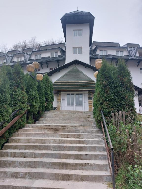 a house with stairs in front of a building at BELE STAZE-Brzece,Kopaonik in Brzeće