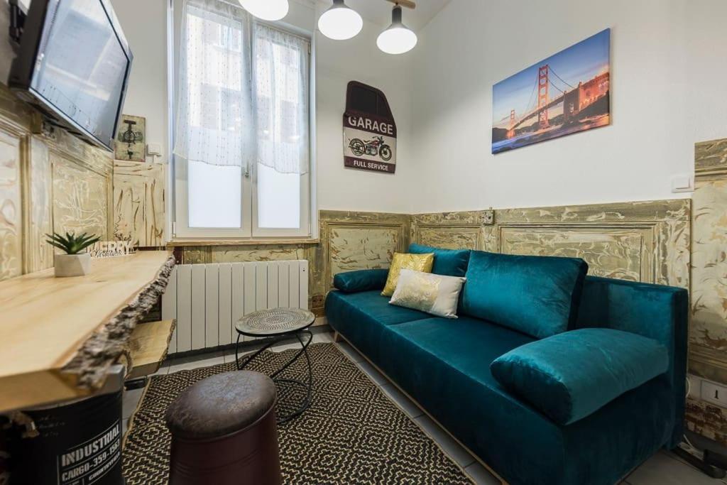 salon z niebieską kanapą i telewizorem w obiekcie St Léon Strasbourg - Studio 3 Pers - Proche centre ville w Strasburgu