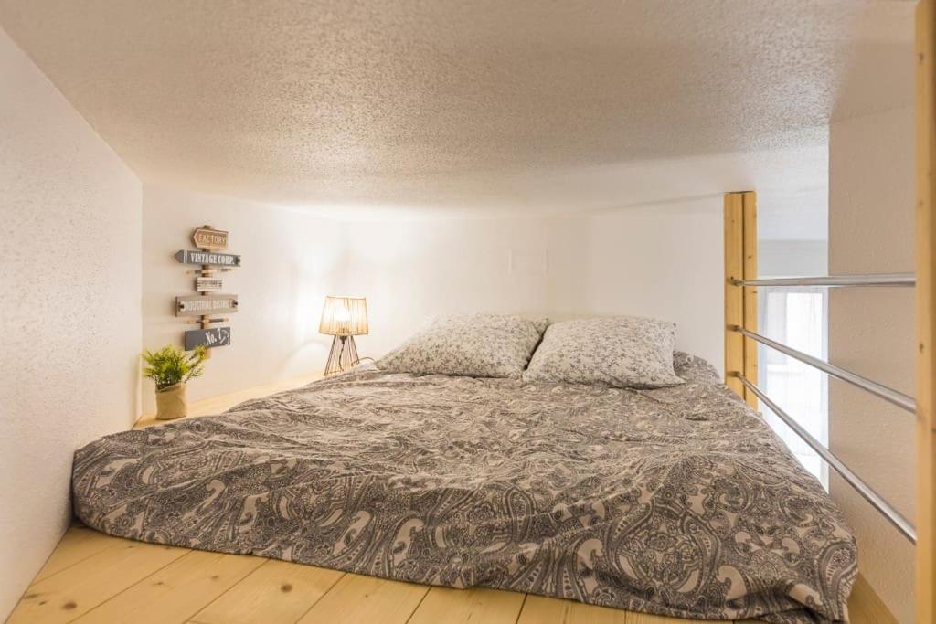 sypialnia z łóżkiem i lampką na drewnianej podłodze w obiekcie St Léon Strasbourg - Studio 3 Pers - Proche centre ville w Strasburgu