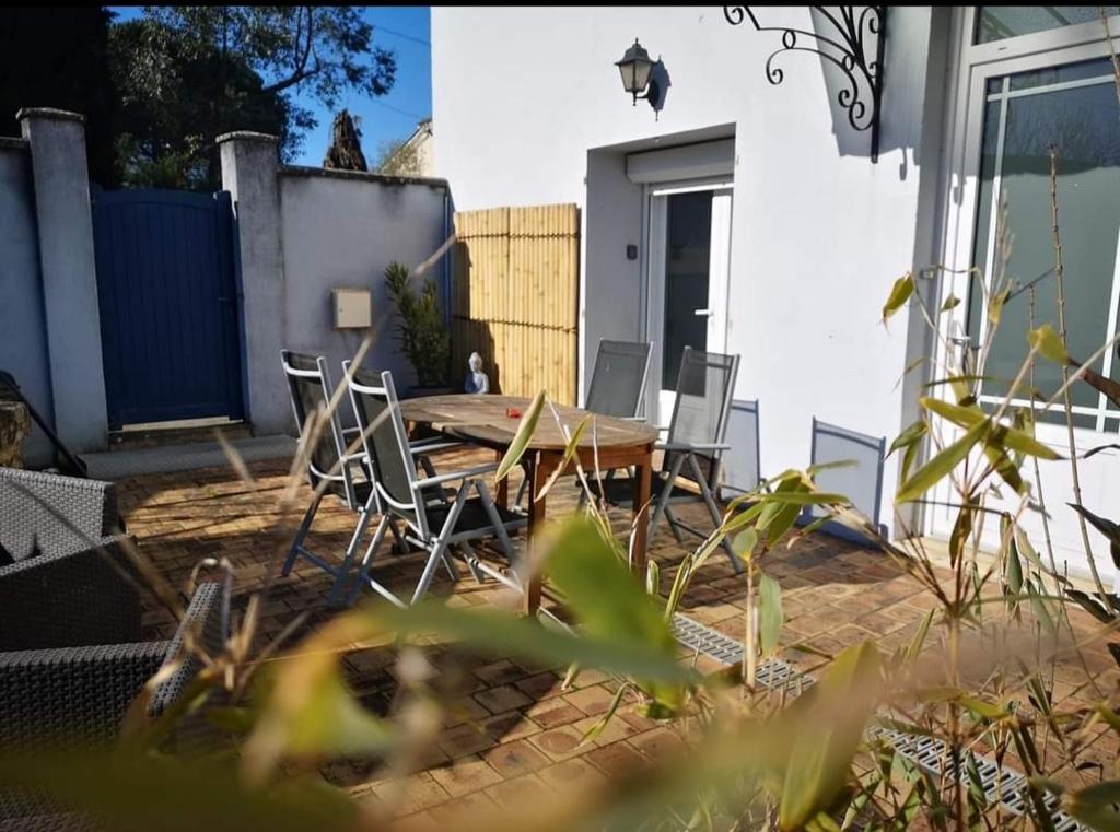 un patio con una mesa de madera y sillas. en Clos Ninastaret, 