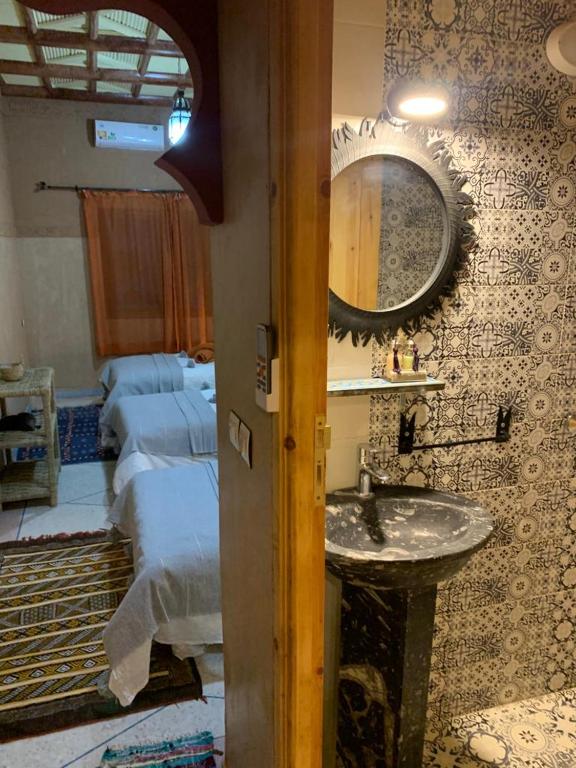łazienka z umywalką i lustrem na ścianie w obiekcie Berber Nomad Kasbah w mieście Nkob