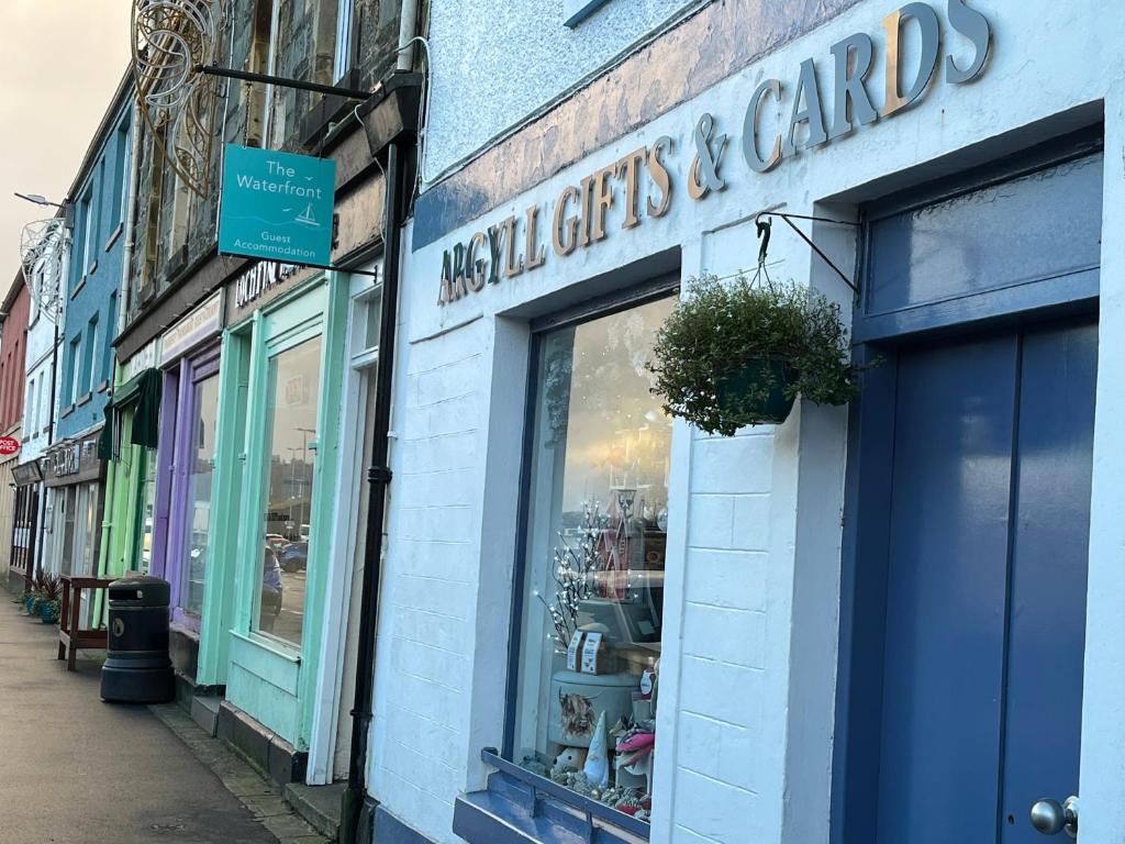 a store with a sign on the side of a building at The waterfront in Tarbert