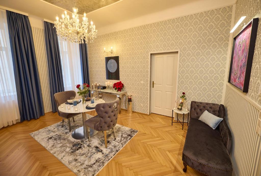 Sophies Place Augarten - Imperial Lifestyle City Apartments Vienna Parking في فيينا: غرفة معيشة مع طاولة طعام وكراسي