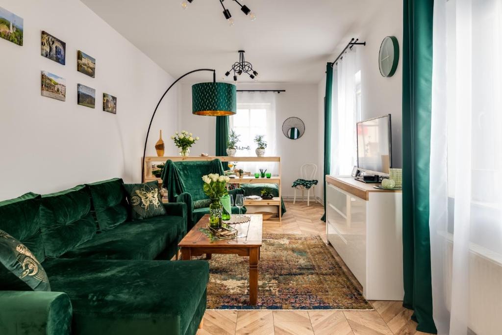 ein Wohnzimmer mit einem grünen Sofa und einem Tisch in der Unterkunft APARTAMENT ZIELONO MI...... in Jedlina-Zdrój