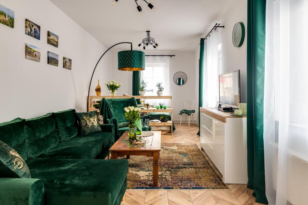 イェドリナ・ズドルイにあるAPARTAMENT ZIELONO MI......の緑のソファとテーブルのあるリビングルーム