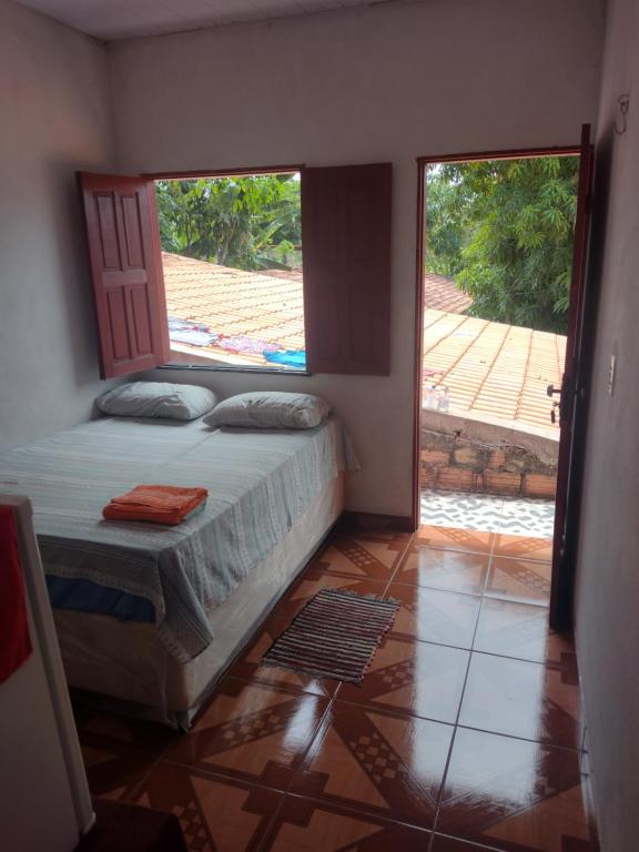 a bedroom with a bed and a large window at Pousada Sombra do Jambeiro in Alter do Chao