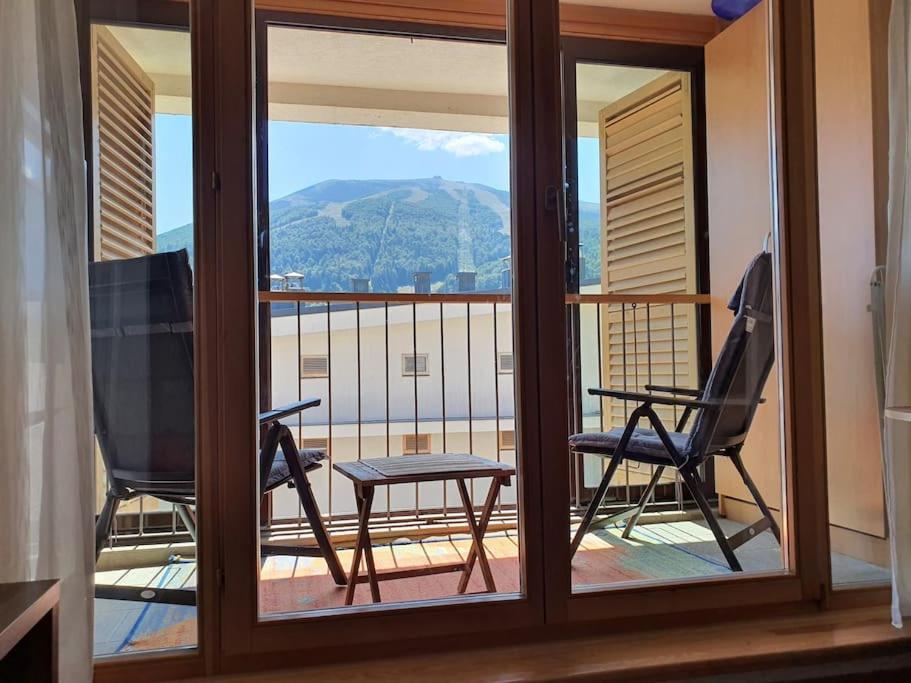 a balcony with a view of a mountain through a window at The Nest - harmony place to spend a mountain brake in Bjelašnica