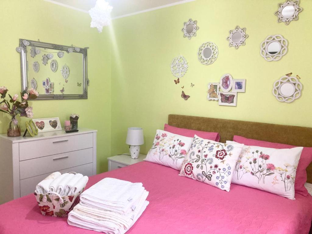 - une chambre dotée d'un lit rose avec des plaques murales dans l'établissement Sweet Butterflies Residence, à Braşov