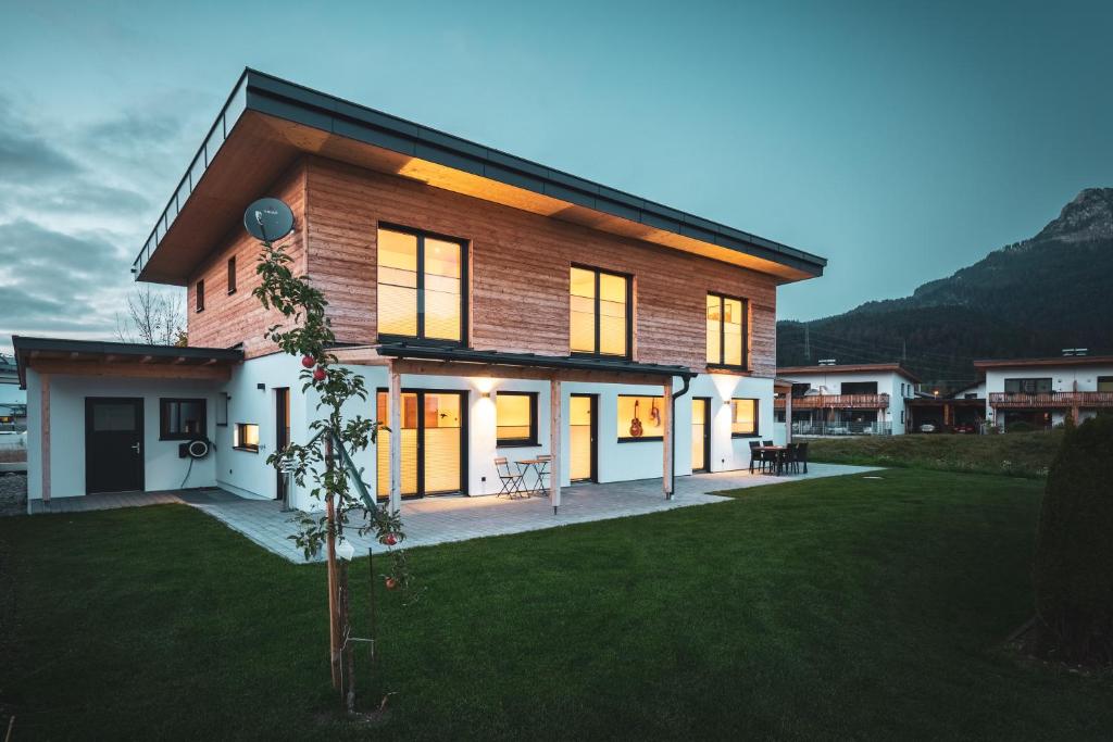 una casa con un césped verde delante de ella en Ferienwohnung Das LechSide en Pflach