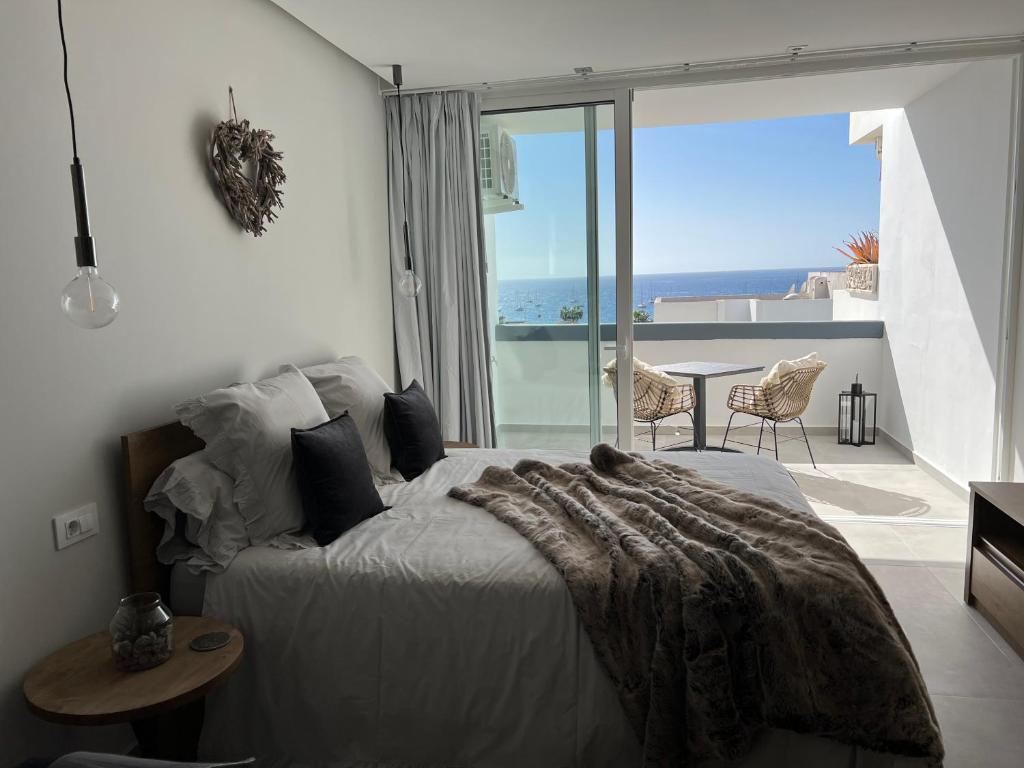 1 dormitorio con 1 cama y vistas al océano en Boutique studio, sea views of Las Vistas and free wifi, en Playa de las Américas