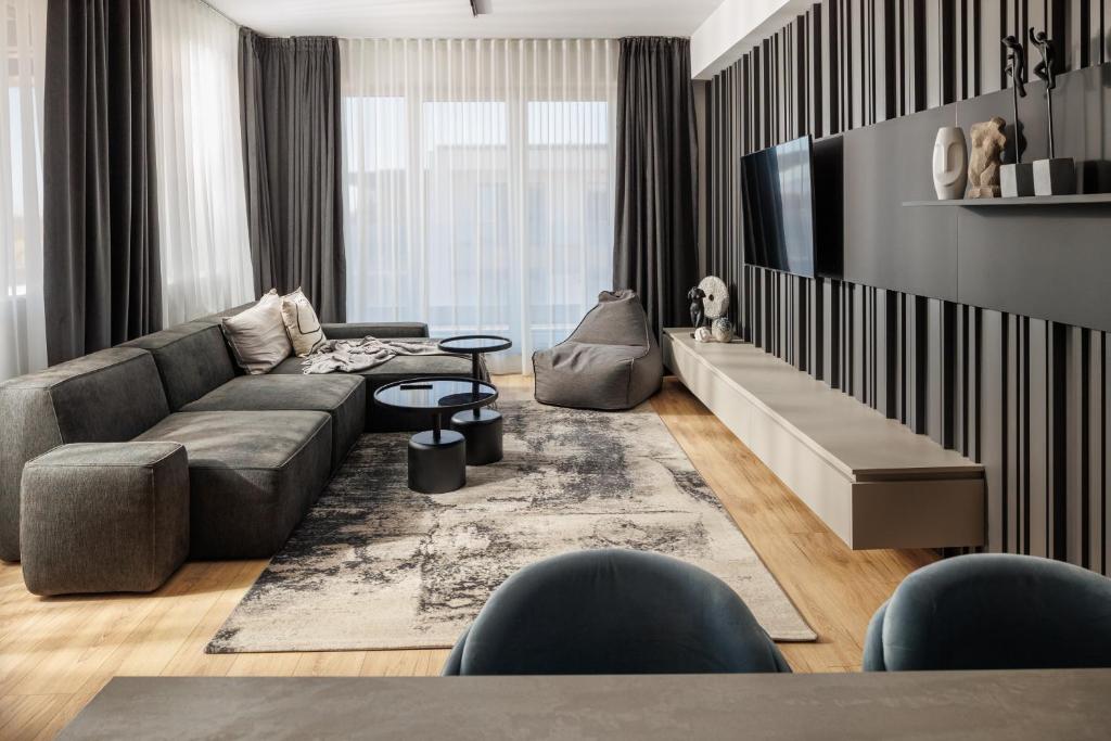 a living room with a couch and a tv at Mandala A Designer Penthouse with Free Private Parking, near Mall Coresi in Braşov
