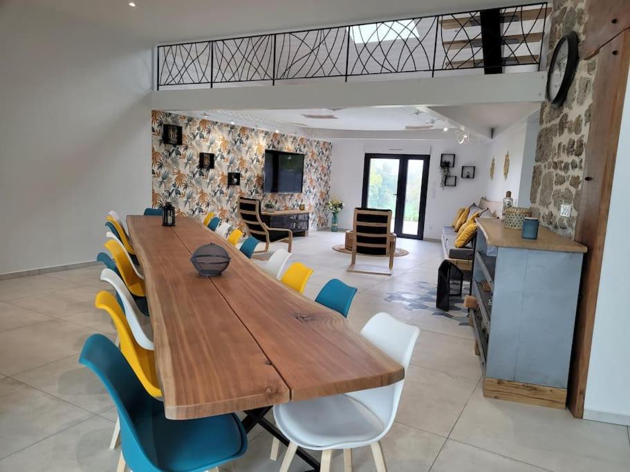 une salle à manger avec une table et des chaises en bois dans l'établissement gîte de l'atelier 15 personnes, à Grazac
