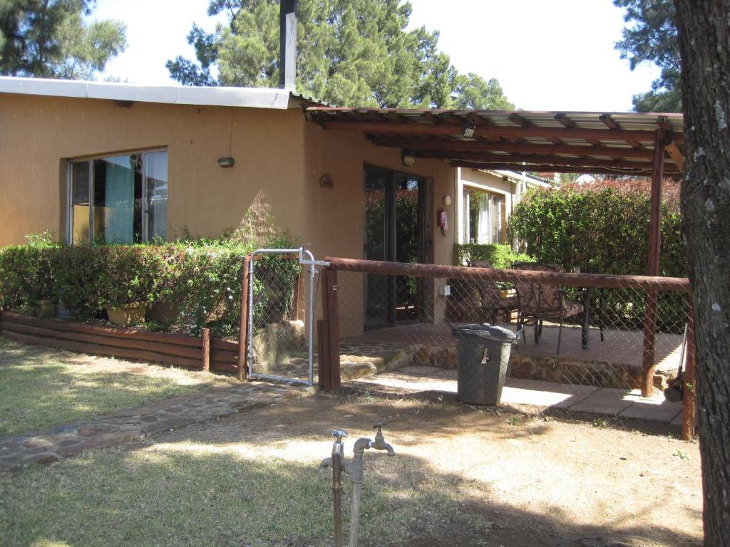 a house with two birds standing in the yard at Blue Roan Country Lodge in Vlakfontein