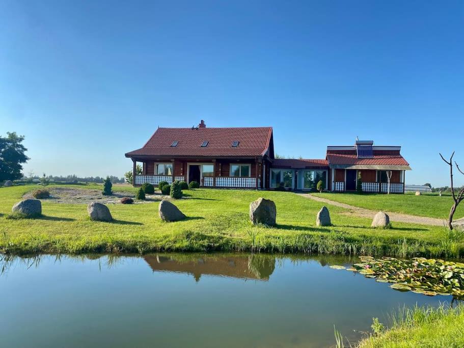 a house with a pond in front of it at Homestead - Ukmergė area 