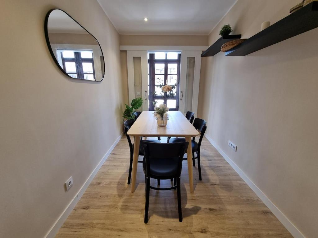a dining room with a table and a mirror at 15A02 Precioso apto en pleno Puerto de Llanes in Llanes