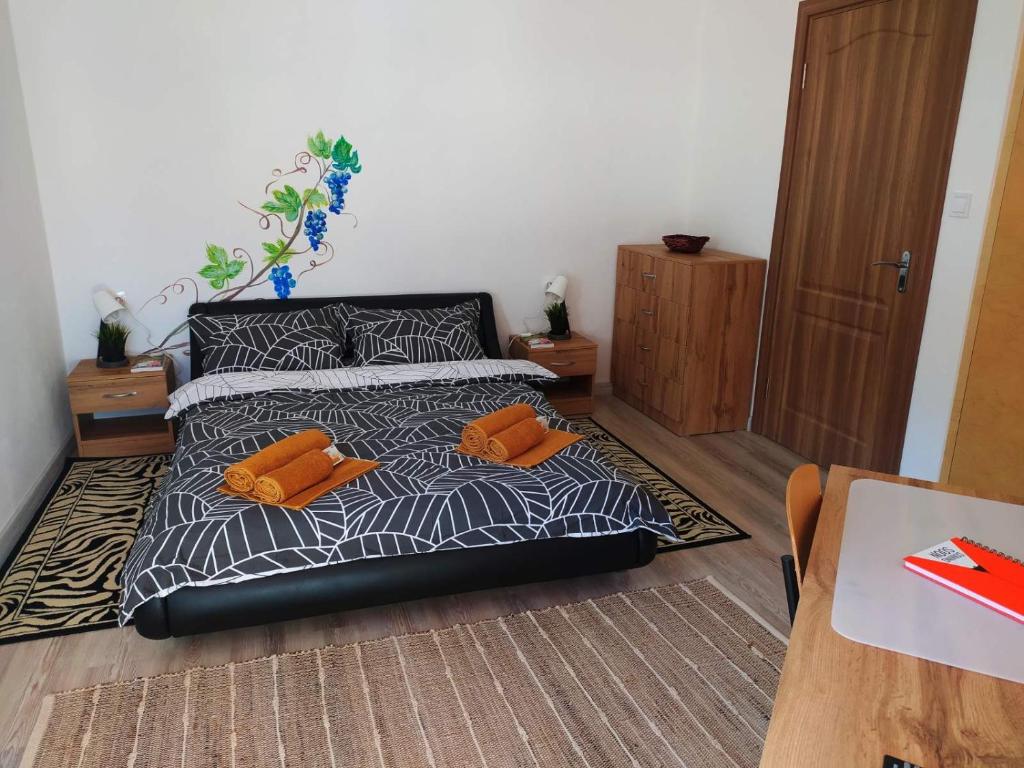 a bedroom with a bed with two orange pillows on it at Дом за Гости Осогово in Kyustendil