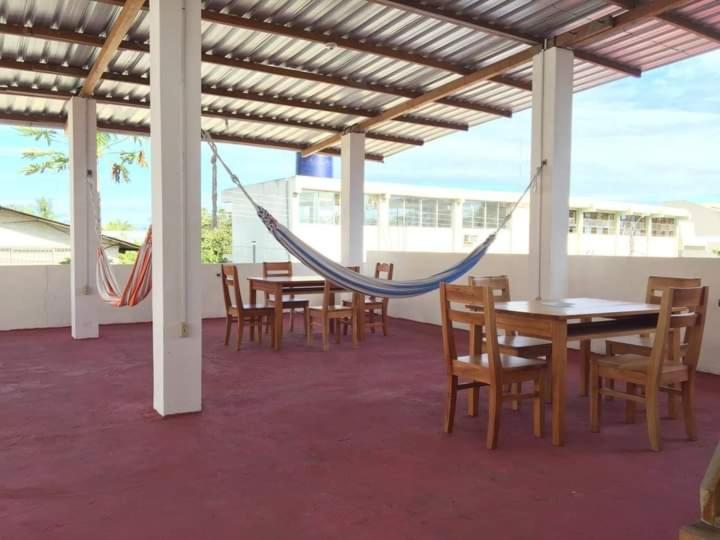 a patio with a hammock and tables and chairs at El Paraiso in Puerto Ayora