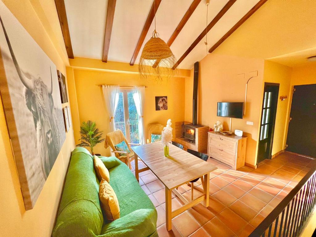 a living room with a green couch and a table at Casa Rural Una Ventana a la Sierra in Aracena