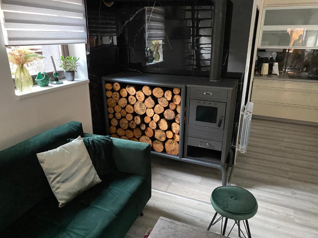 a living room with a couch and a stove with logs at Apartman Kateřinky Liberec in Liberec