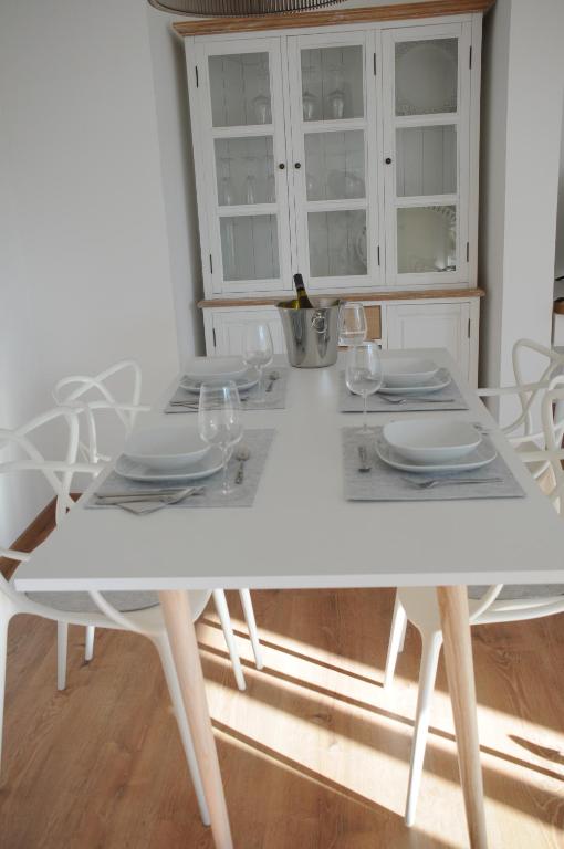 una mesa de comedor blanca con platos blancos. en RELAX Apartment mit Garten - Lifestyle am Bodensee, Fahrräder inklusive en Bregenz