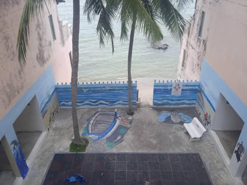 einen Blick über den Strand mit Palmen in der Unterkunft Seaview Pd homestay Apartment in Port Dickson