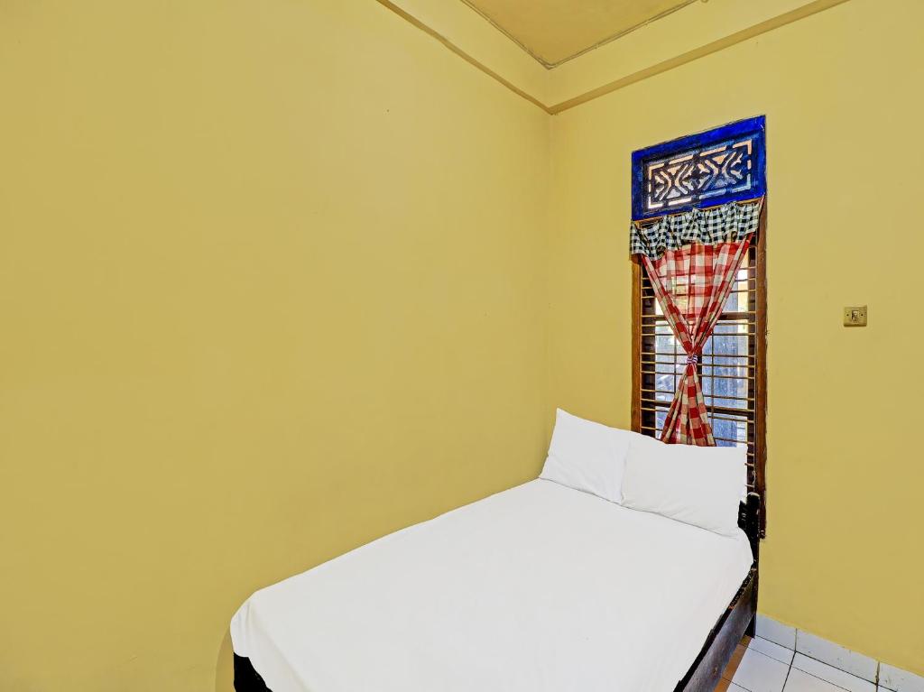 a bedroom with a white bed and a window at OYO 91235 Pondok Damu in Kapal