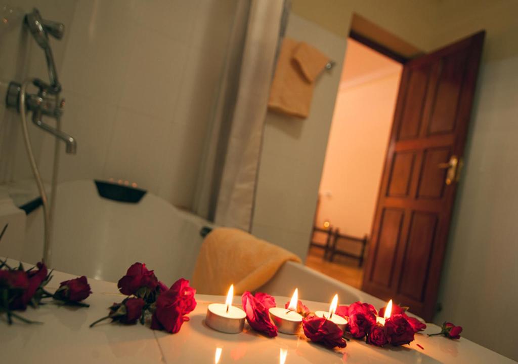 una mesa con rosas rojas y velas. en Ashiyana Cliff and Beach Resort, en Varkala