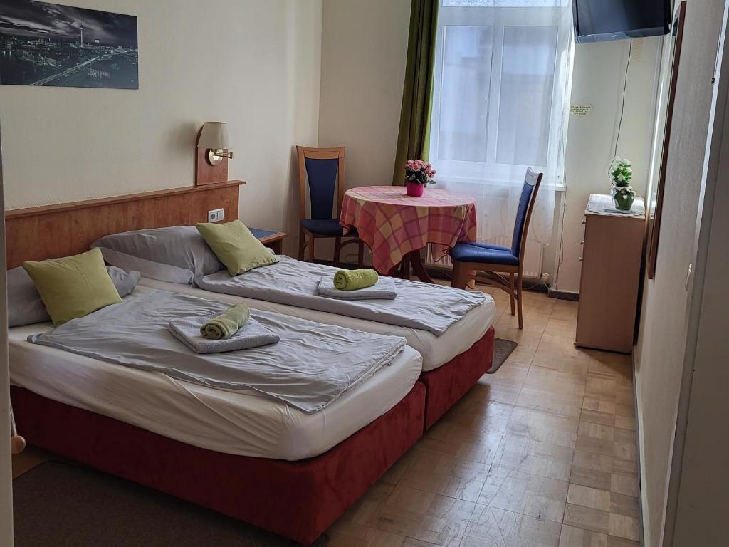 1 dormitorio con 1 cama, mesa y sillas en Pension Hubertus en Berlín