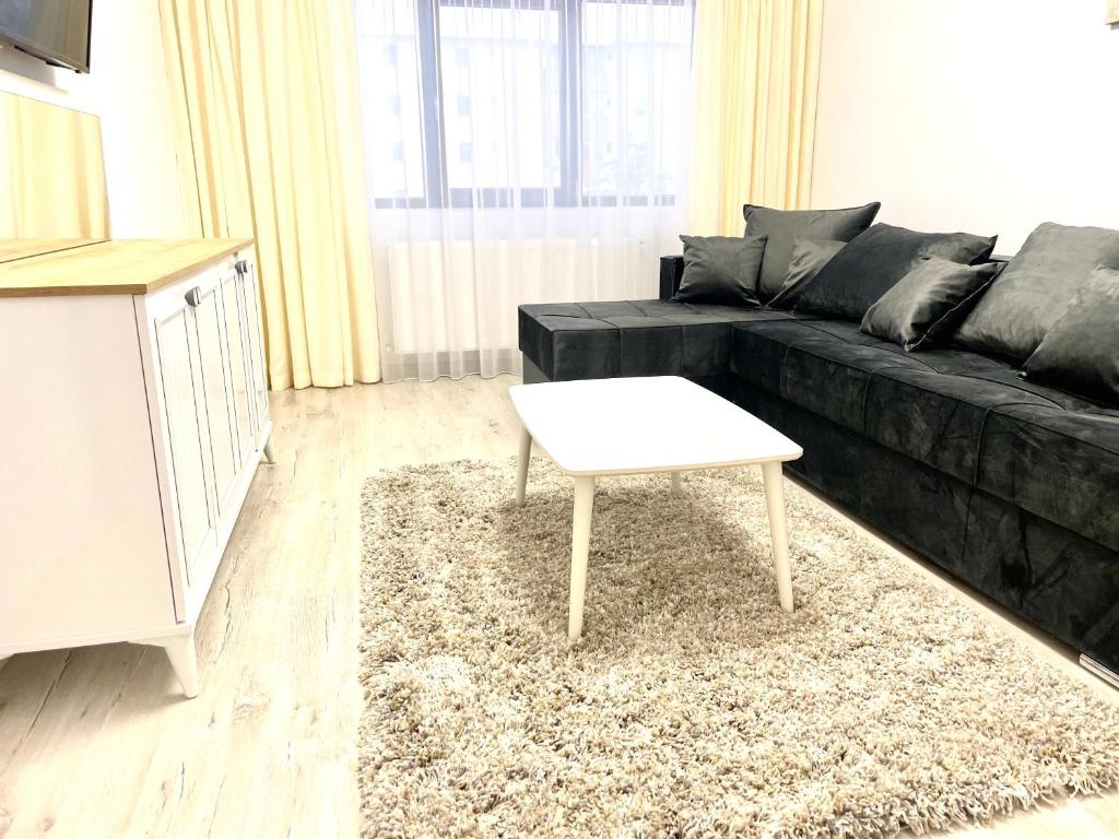 sala de estar con sofá negro y mesa de centro blanca en TAJ en Ipoteşti