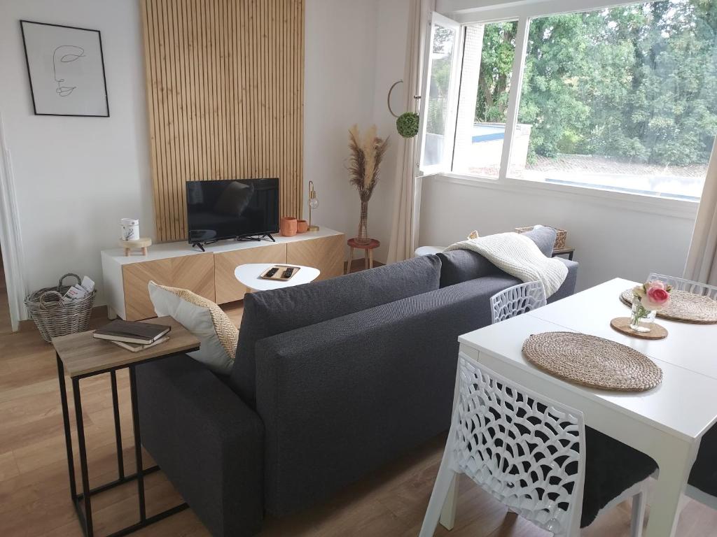 un salon avec un canapé et une table dans l'établissement Au Nid d'or : Appartement Tout confort Hyper Centre Béthune, à Béthune