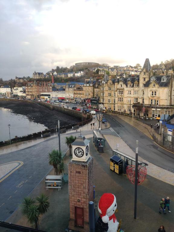 a clock tower with a santa hat next to a city at Station View in Oban