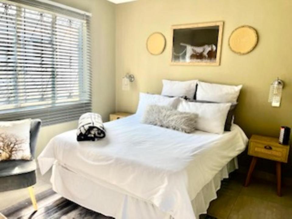 1 cama blanca grande en una habitación con ventana en Emba Guest lodge No loadshedding, en eMbalenhle