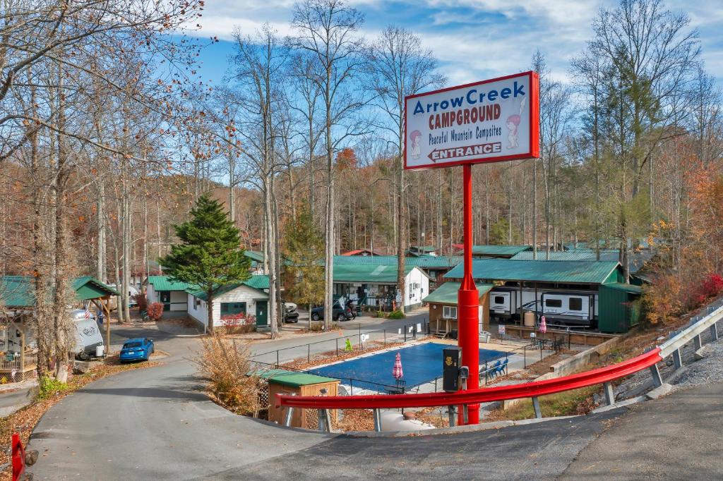 a sign in front of a resort with a swimming pool at Arrow Creek Camp and Cabins in Gatlinburg