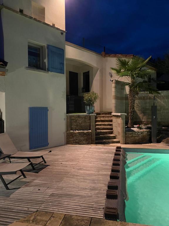 a villa with a swimming pool in front of a house at Chambre au calme avec spa privatif gratuit sud aveyron les palmiers des causses in Saint-Rome-de-Tarn