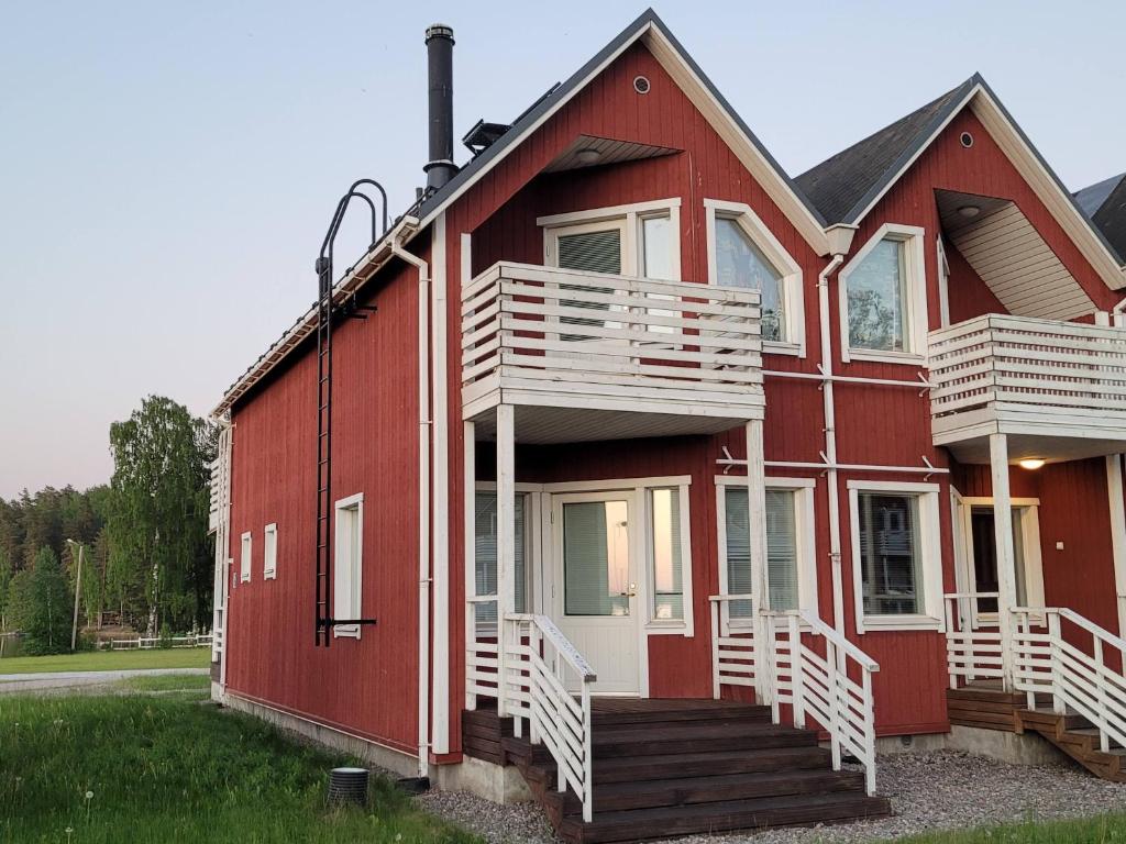 a red house with white stairs on the side of it at Saimaa Marina Garden Apartments in Lappeenranta