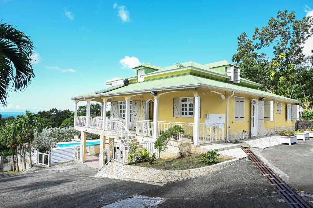 una casa amarilla con una piscina frente a ella en Villa D ENNRY, en Pointe-Noire